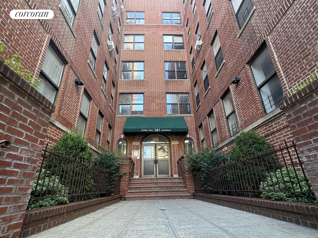 a front view of a multi story building with yard