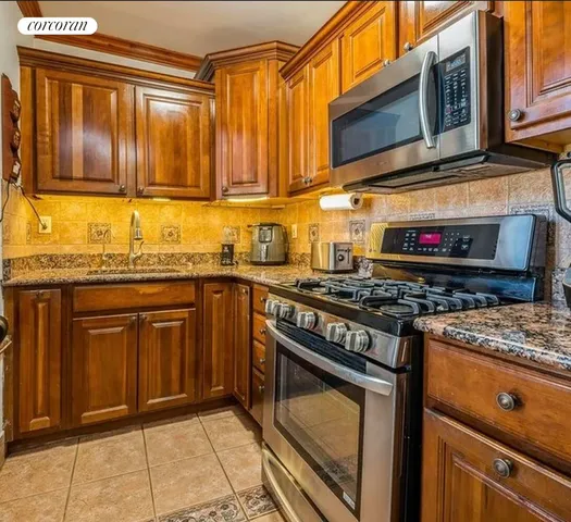 a kitchen with stainless steel appliances granite countertop a stove a sink and a microwave
