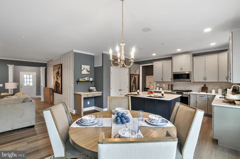 a view of a dining room with furniture a kitchen and chandelier