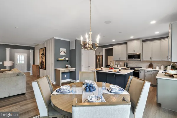 a view of a dining room with furniture a kitchen and chandelier