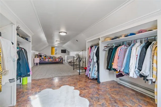 a view of walk in closet with clothes and shoes