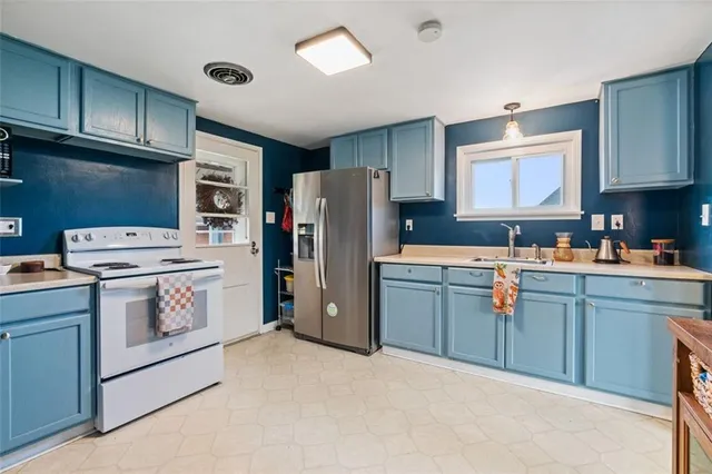 a kitchen with a refrigerator sink and cabinets