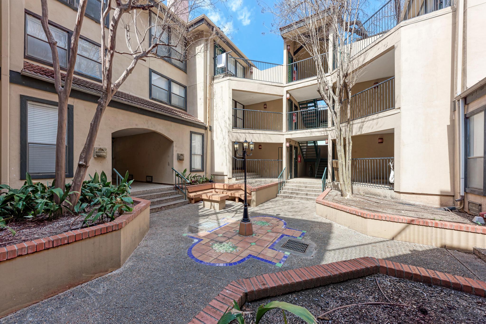 a view of a building with potted plants and a bench