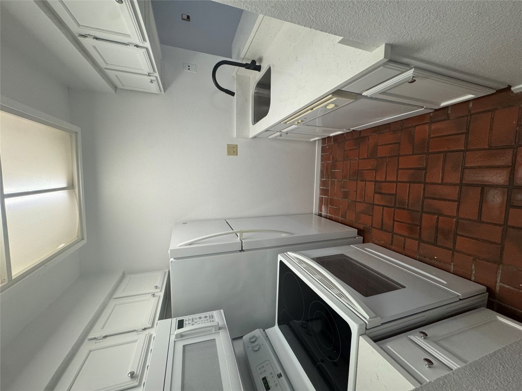2110 Rio Grande Street, Unit 107 Austin, TX 78705 - Photo 5 of 9 a kitchen with a sink a stove and cabinets