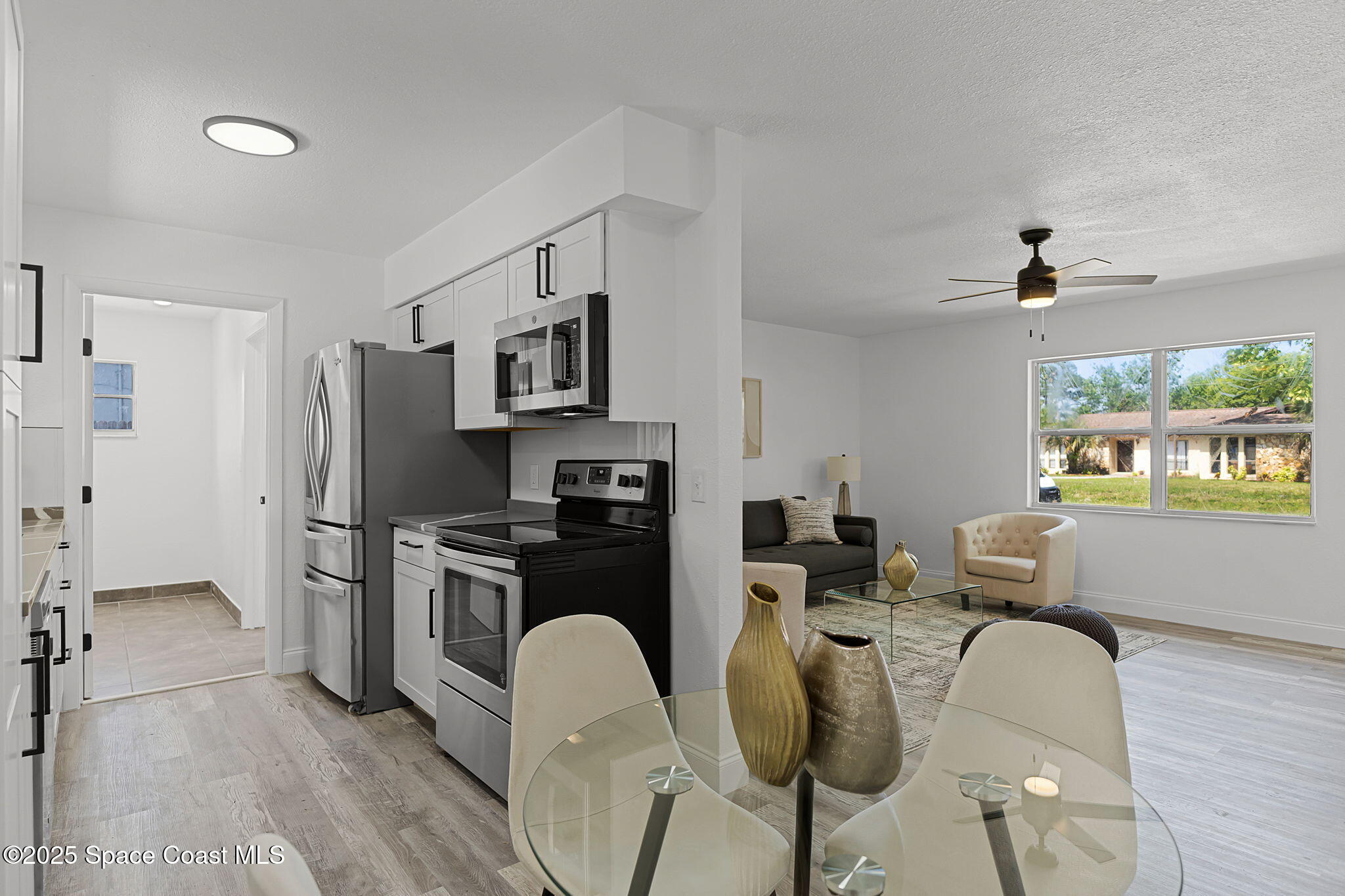 2412 Yule Tree Drive Edgewater, FL 32141 - Photo 11 of 35 a kitchen with stainless steel appliances a refrigerator a stove a oven a dining table and chairs with wooden floor