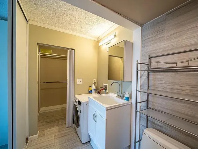 a bathroom with a sink a toilet and shower