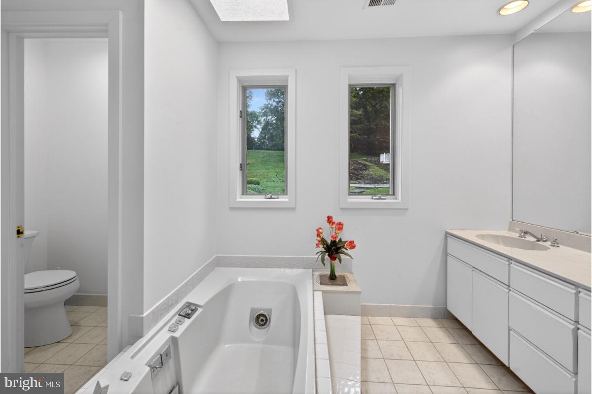 10320 Glen Road Potomac, MD 20854 - Photo 15 of 75 a bathroom with a tub sink toilet and mirror