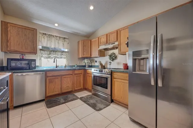 a kitchen with stainless steel appliances granite countertop a refrigerator sink and cabinets