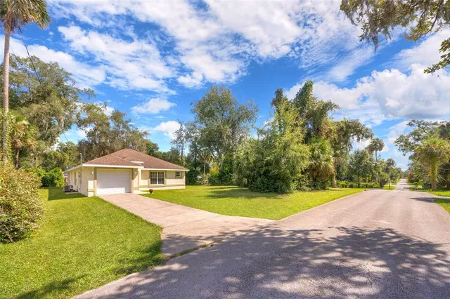 a view of a house with a yard and shrubs