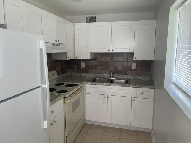 a view of an empty room with a chandelier fan