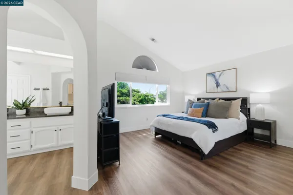 a spacious bedroom with a bed and a large window