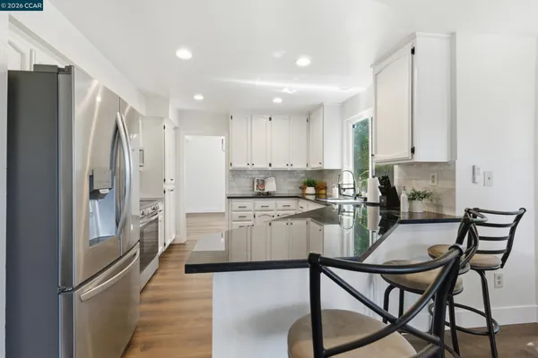 a kitchen with refrigerator and cabinets