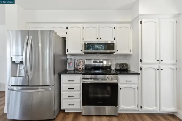 a kitchen with cabinets stainless steel appliances and a counter space