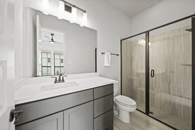 a bathroom with a sink toilet a mirror and shower