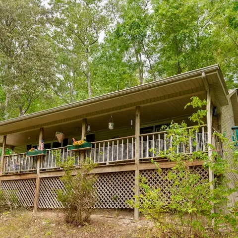 a view of a balcony with two chairs and wooden fence