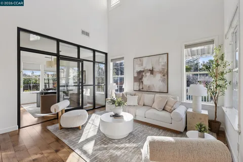 a living room with furniture and a large window with garden view