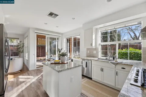 a kitchen with a stove and a white sink