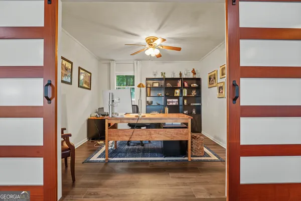 a living room with furniture and a bookshelf with wooden floor