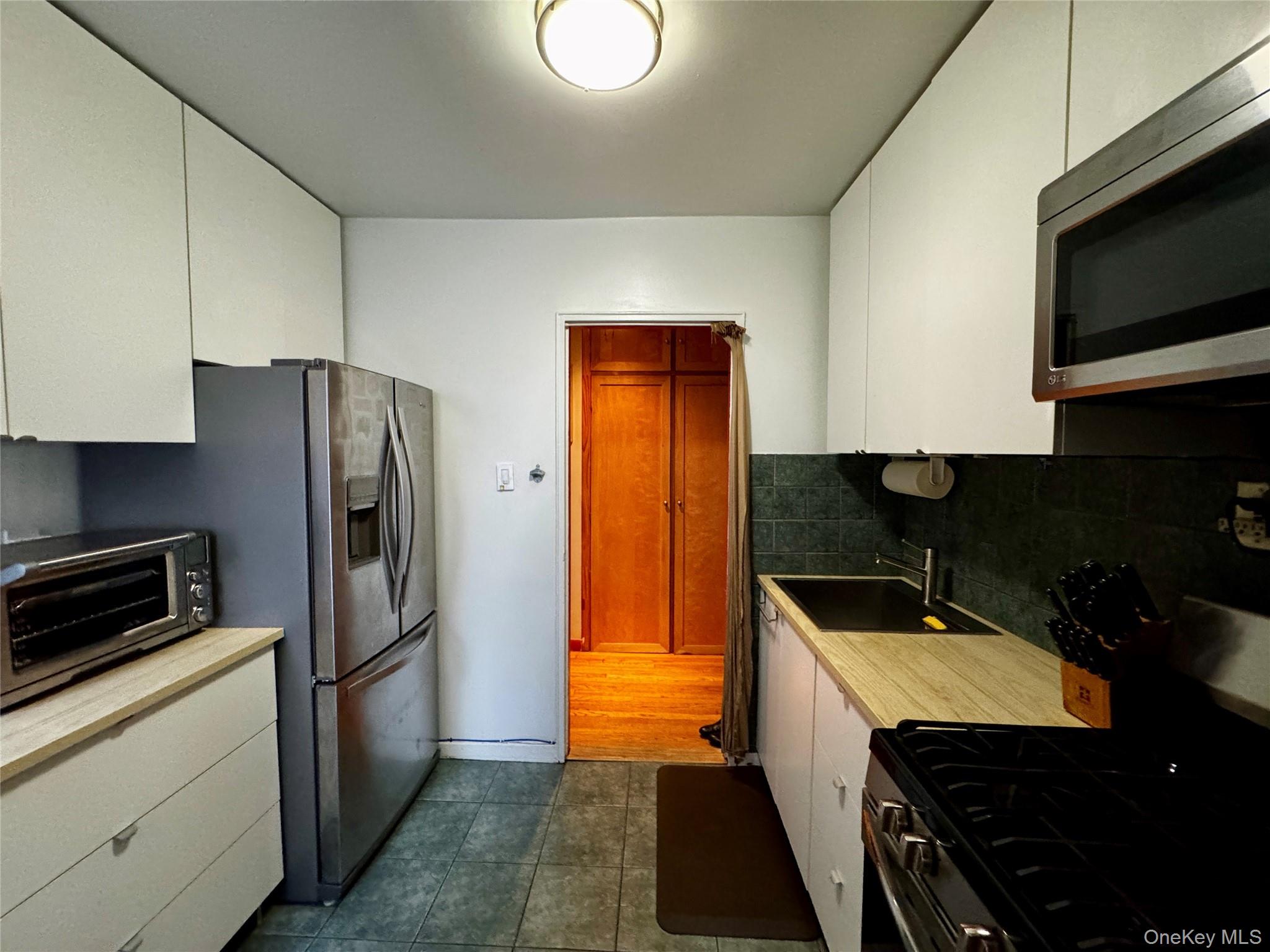 65-45 Yellowstone Boulevard, Unit 2A Queens, NY 11375 - Photo 4 of 9 a kitchen that has a sink and a refrigerator