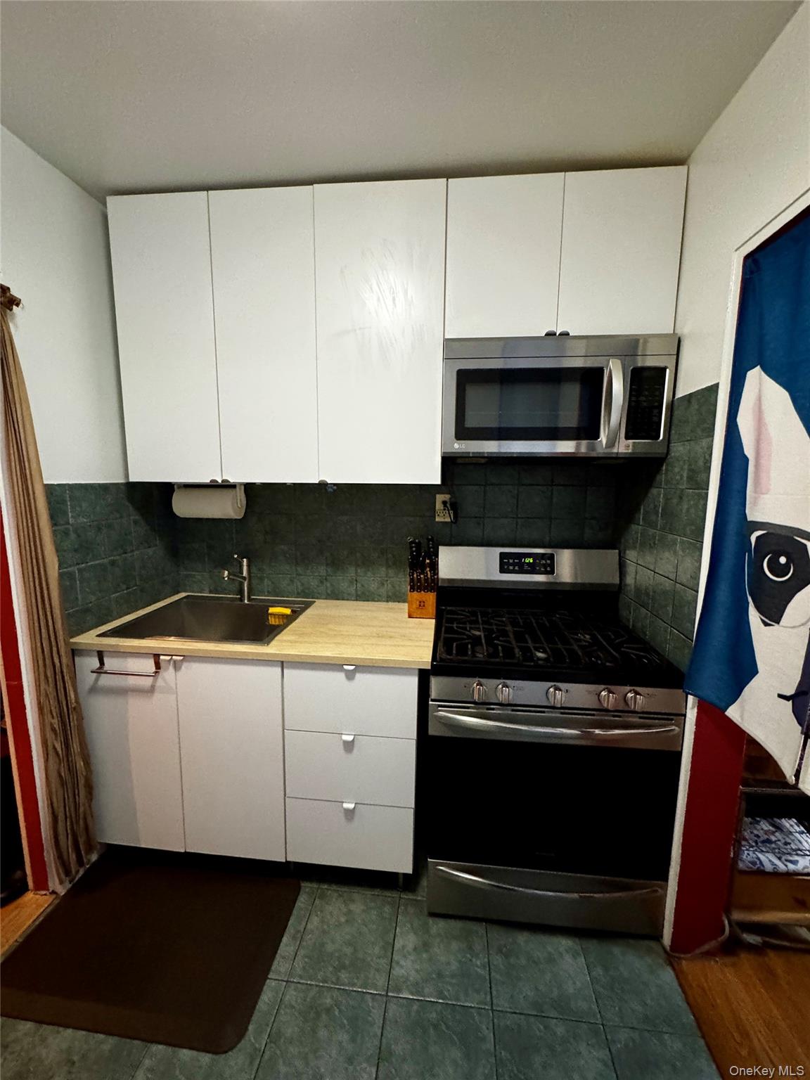 65-45 Yellowstone Boulevard, Unit 2A Queens, NY 11375 - Photo 6 of 9 a kitchen with granite countertop a stove and a microwave