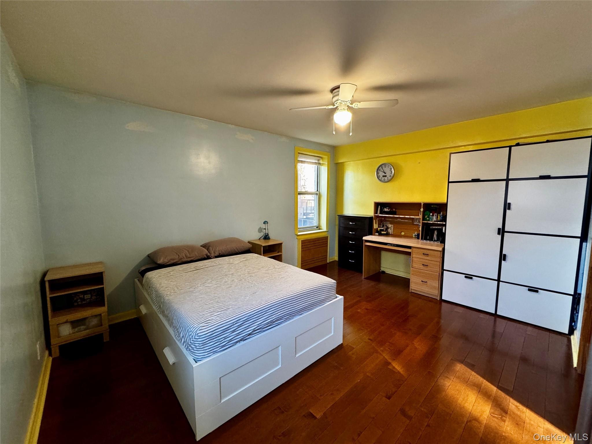 65-45 Yellowstone Boulevard, Unit 2A Queens, NY 11375 - Photo 8 of 9 a spacious bedroom with a bed and a chandelier