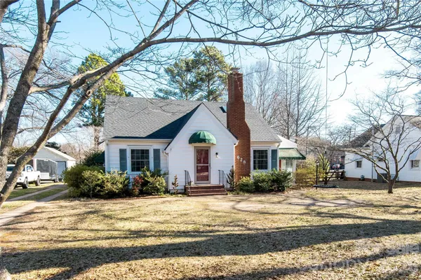 a front view of house with yard and trees around