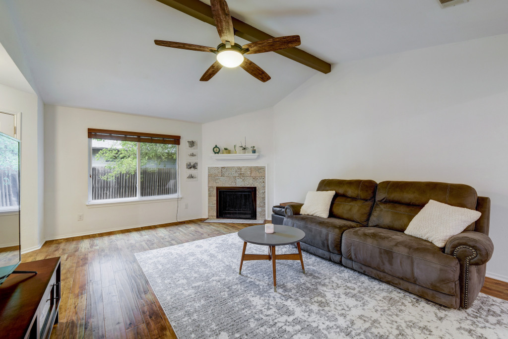 6002 Baton Rouge Drive Austin, TX 78727 - Photo 5 of 20 Living space featuring vaulted ceilings with exposed wood beams, a ceiling fan with integrated lighting, and wood-finish flooring