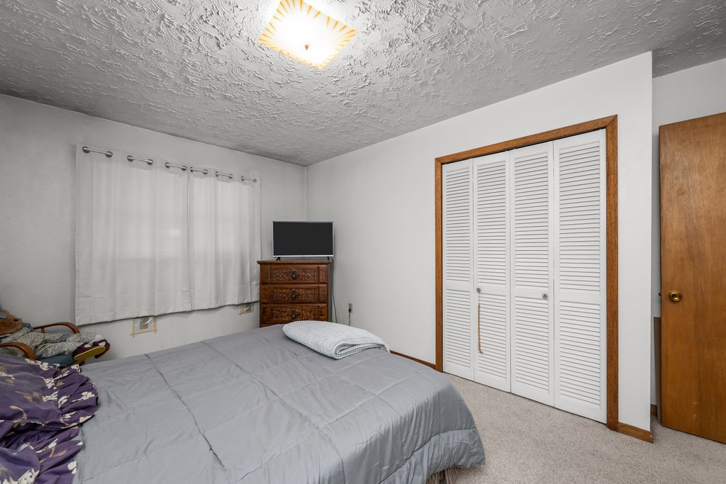 11213 22nd Street Milan, IL 61264 - Photo 9 of 36 a bedroom with a bed and a television