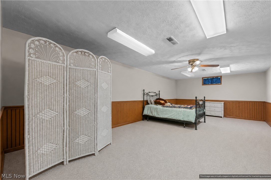 1835 Lynn Road Kent, OH 44240 - Photo 17 of 48 Spacious room featuring carpeting, wood-paneled wainscoting, and a ceiling fan with integrated lighting