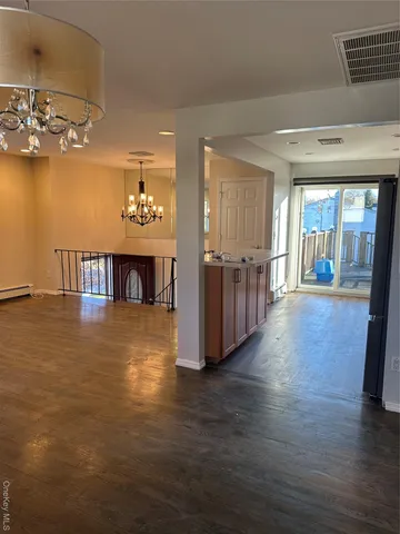a view of a livingroom with wooden floor and a kitchen