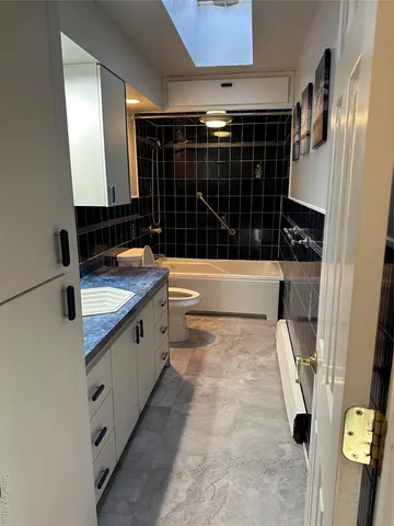 an empty room with wooden floor and kitchen view