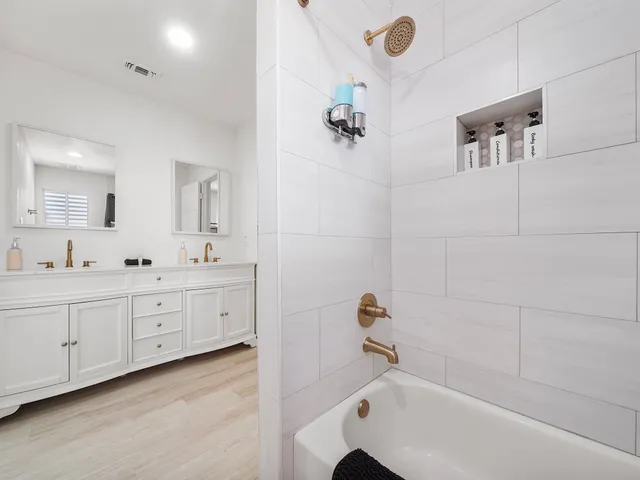 a spacious bathroom with a tub sink and mirror