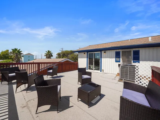 a view of a patio with couches table and chairs and potted plants