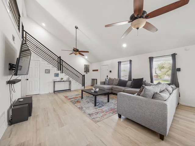 a living room with furniture and a ceiling fan
