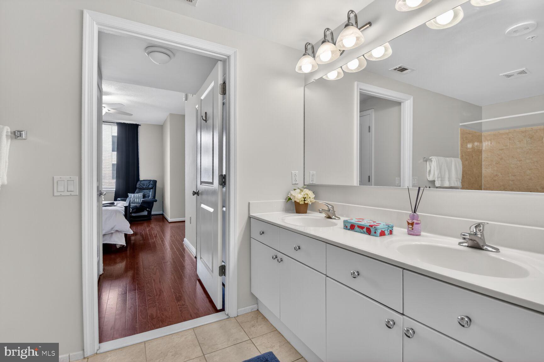 930 Wayne Avenue, Unit 405 Silver Spring, MD 20910 - Photo 18 of 68 a en suite bathroom with a double vanity sink and a mirror