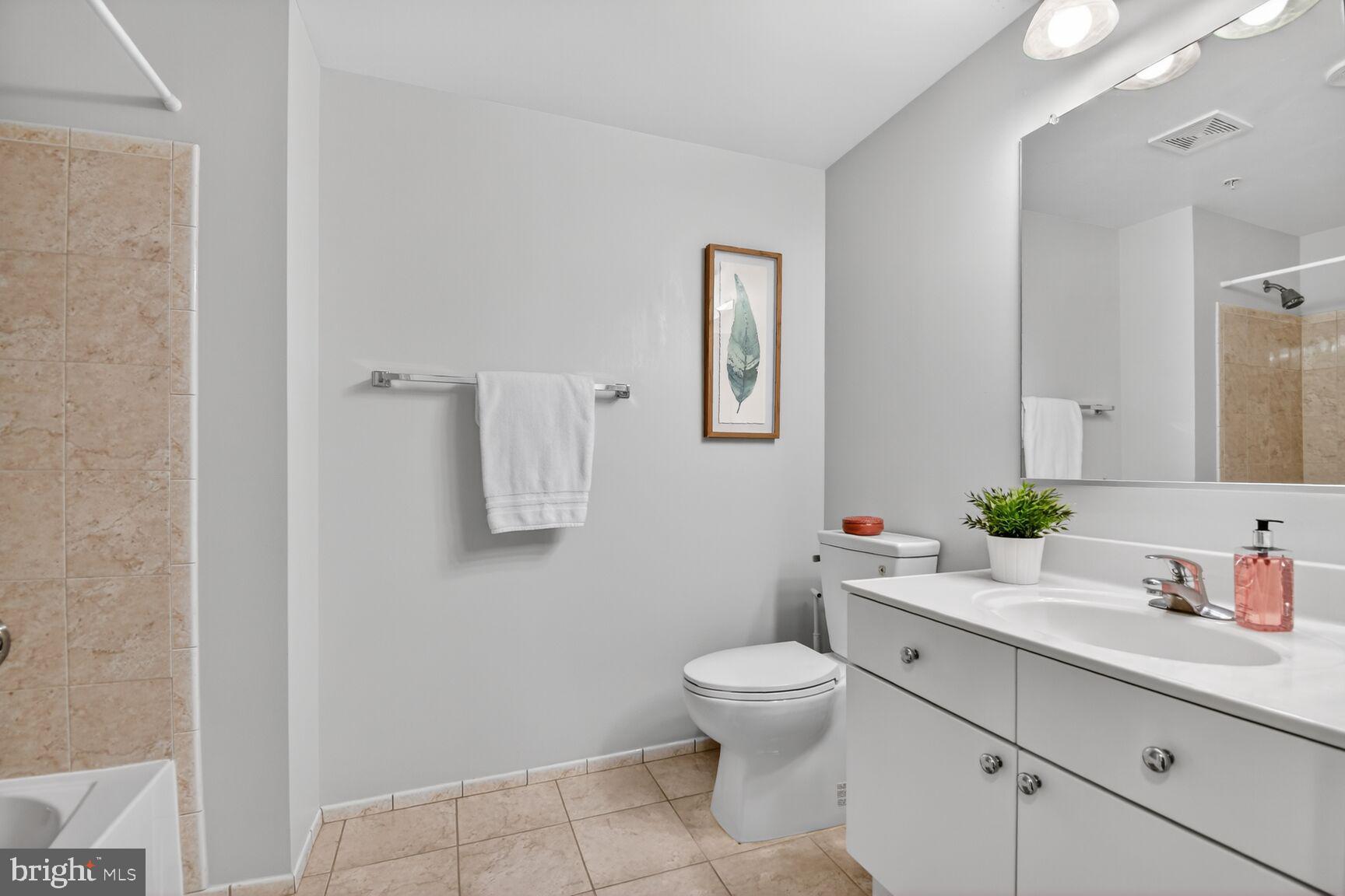 930 Wayne Avenue, Unit 405 Silver Spring, MD 20910 - Photo 27 of 68 a bathroom with a toilet sink and mirror