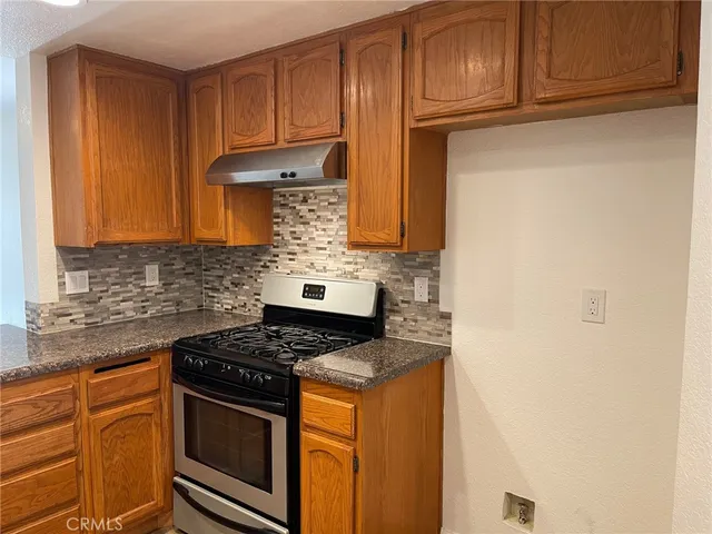a kitchen with granite countertop cabinets and steel stove top oven