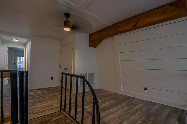 a view of a hallway with wooden floor and staircase