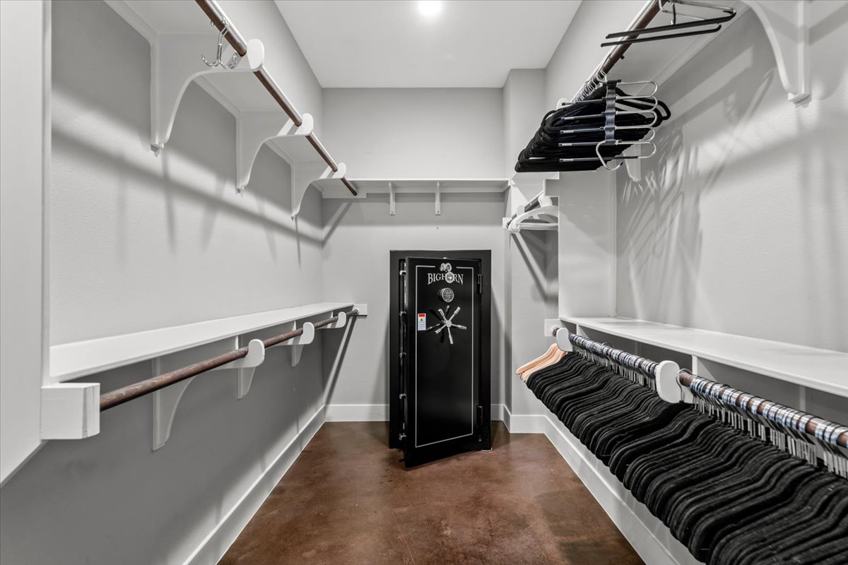 913 Stobaugh Street, Unit B Austin, TX 78757 - Photo 27 of 40 Walk-in closet with ample storage, featuring built-in shelving and hanging rods for organized living. Large safe offers an added feature.