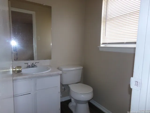 a bathroom with a toilet sink and mirror