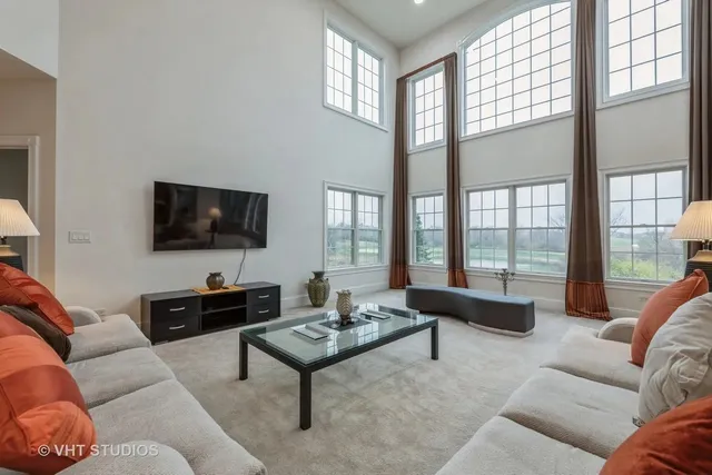 a living room with furniture a flat screen tv and a large window