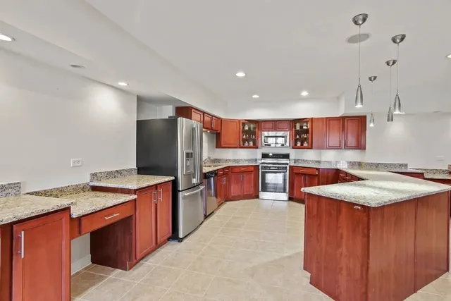a kitchen with stainless steel appliances granite countertop wooden cabinets sink and stove