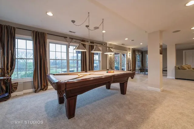 a room with pool table and windows