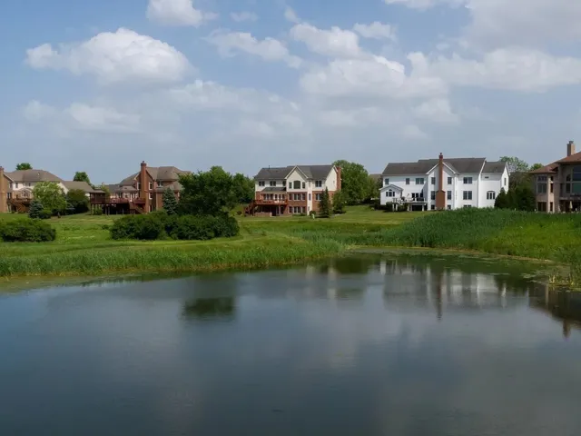 an aerial view of a house with a yard and lake view