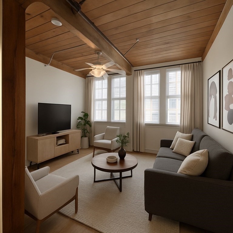 7 Marble Street, Unit 206E Whitman, MA 02382 - Photo 1 of 6 a living room with furniture and a flat screen tv