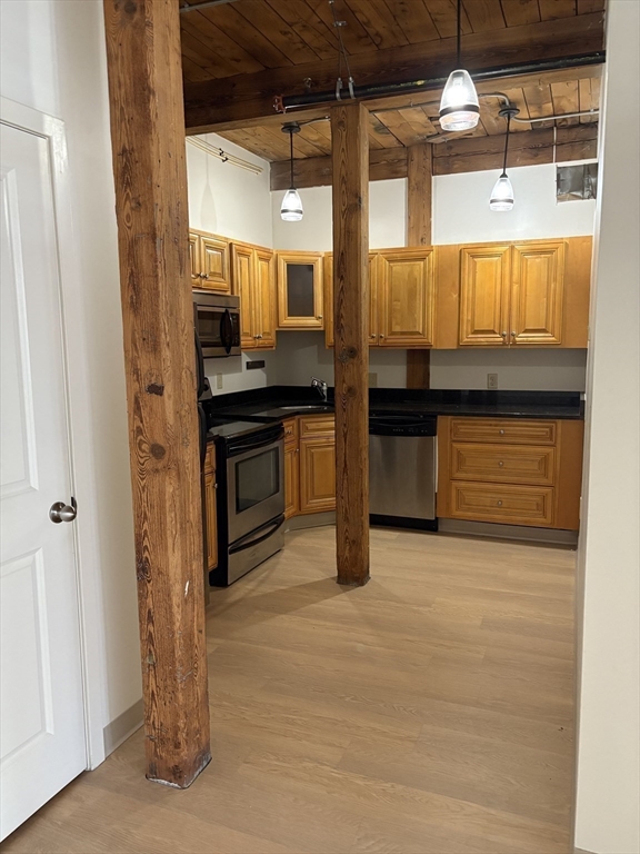 7 Marble Street, Unit 206E Whitman, MA 02382 - Photo 4 of 6 a kitchen with stainless steel appliances granite countertop a stove and a refrigerator