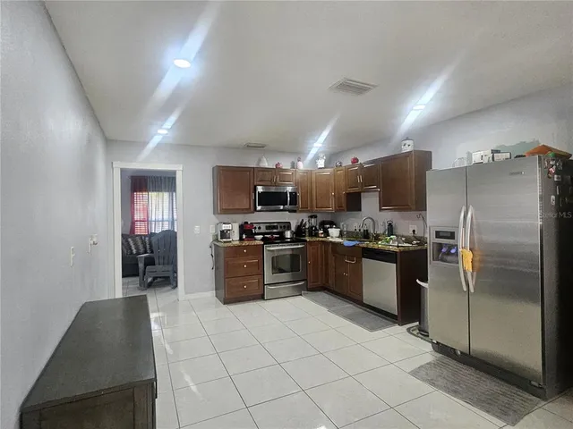 a large kitchen with a large counter top stainless steel appliances and cabinets