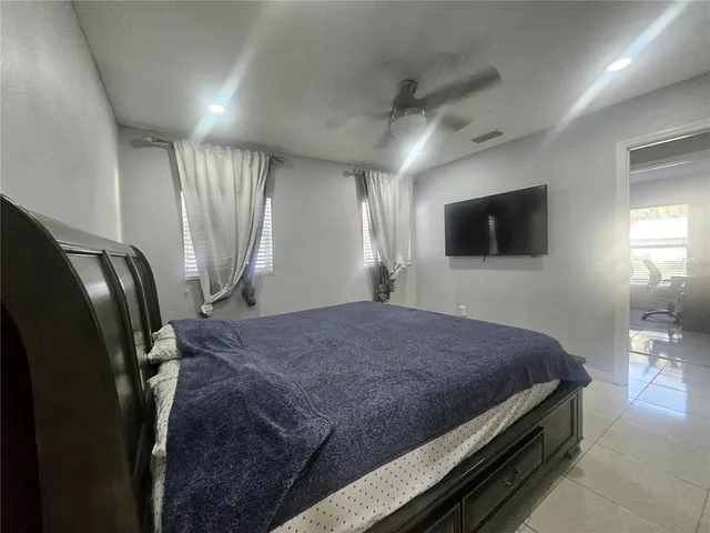 a bedroom with a bed window and a television