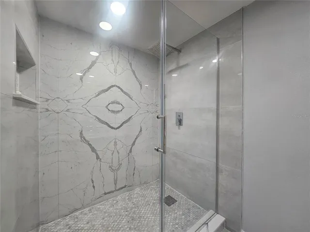 a bathroom with a shower and mirror
