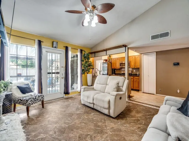 a kitchen with stainless steel appliances granite countertop a stove top oven a sink a dining table and chairs with wooden floor